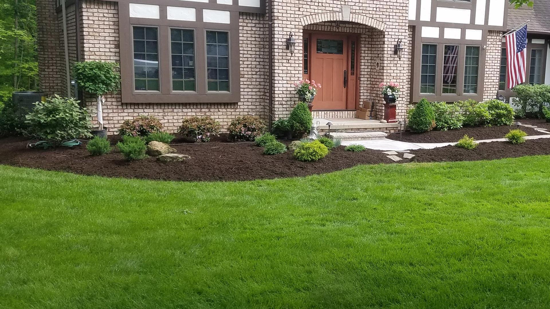 Residential yard after a fall clean up with re-shaped landscape beds, new mulch, and trimmed grass in Medina, OH.
