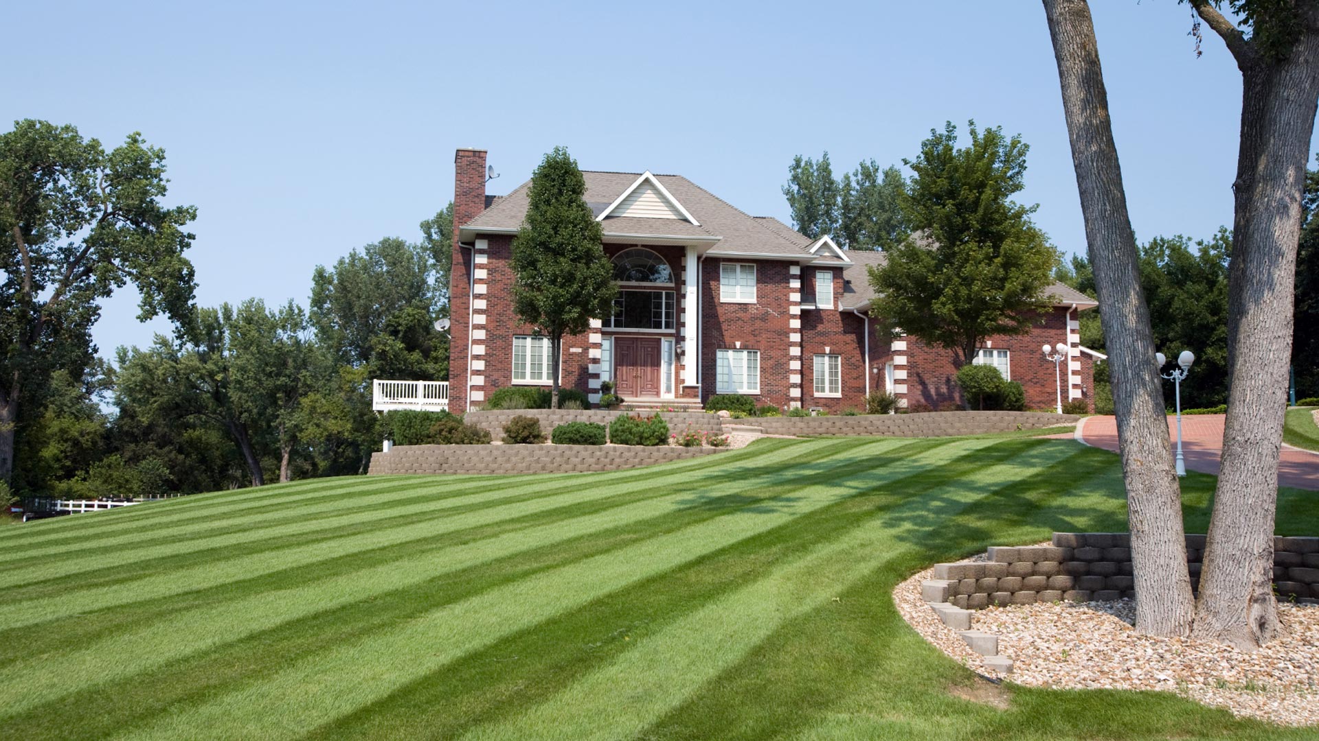 Lawn mowed with stripes and new landscaping installation at a home in Medina, OH.